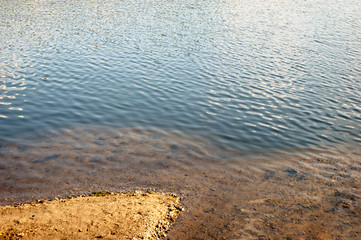 Sandy coast and ripple water with sky reflection, natural mirror, nature wonders