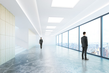 Businessmen in concrete corridor