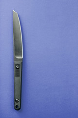 Black knife on yellow background. survival and bushcraft concept