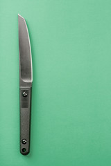 Black knife on yellow background. survival and bushcraft concept