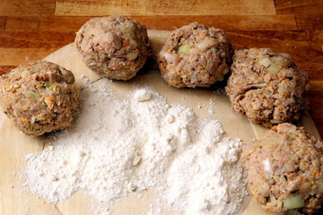 Rissoles, made from minced meat, onion and breadcrumbs, ready to be rolled in flour and fried