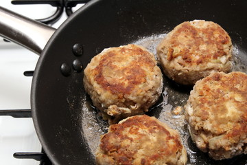 Rissoles, made from minced meat, onion and breadcrumbs, frying in a pan