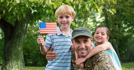 Portrait of father in soldier uniform with their kids at park