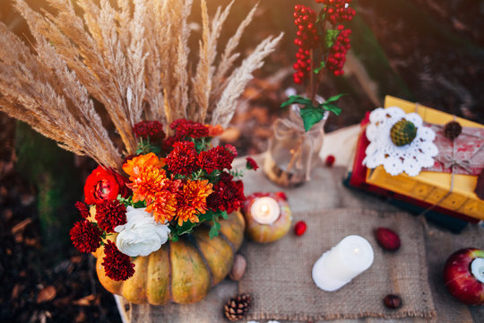 Romantic autumn scenery for photo shoots. Old books, flowers, pumpkins, apples, lace and candles