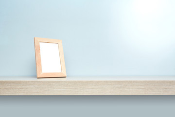 Mensola in legno su fondo grigio con cornice © CreativePhotography