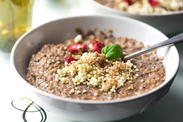 Chocolatiers breakfast with oatmeal, puffed rice, cereals and dried strawberries   in a white bowl.  