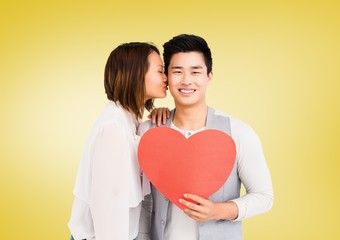 Fototapeta na wymiar Woman kissing man while holding heart