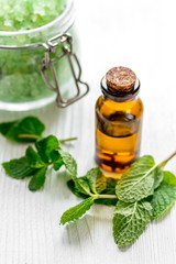 organic cosmetics with herbal extracts of mint on wooden background
