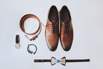 Men's shoes, tie, watches, belt on the light background