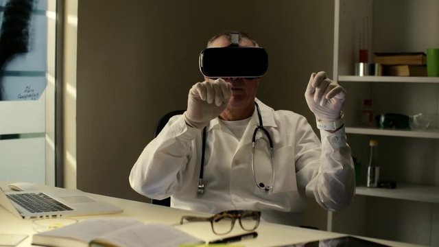 Professional surgeon doctor uses virtual 3D 360 training center with headset VR glasses to teach and show audience a surgery to a patient in the cyberspace