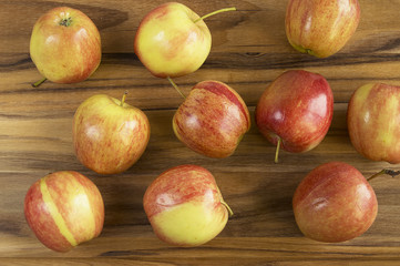 Scattered red and yellow apples on wood