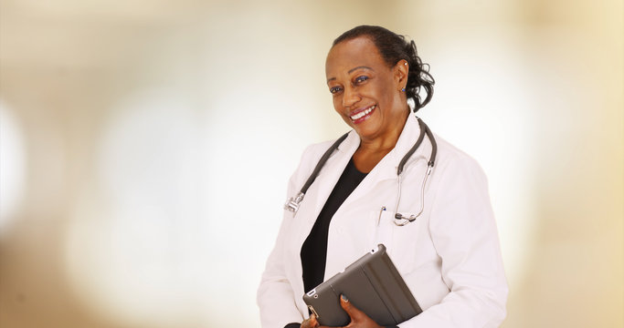 An Older Black Doctor Posing For A Portrait In Her Office