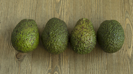 Avocados in the middle of a wood table