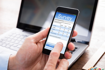 Businessman Filling Survey Form On Mobile Phone