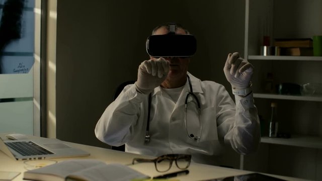 Professional surgeon doctor uses virtual 3D 360 training center with headset VR glasses to teach and show audience a surgery to a patient in the cyberspace