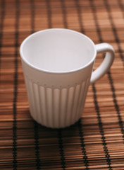 A light cup on a wooden napkin