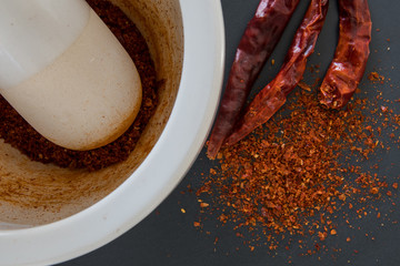 Edge of Mortar and Pestle with Ground and Whole Thai Chili