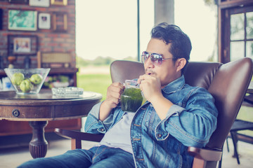 Young man with smartphone smiling relaxing at cafe.