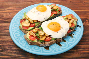 Sandwich with egg, tomato, greens, and mushrooms