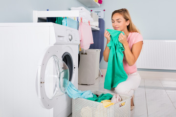 Woman Smelling Clothes After Washing