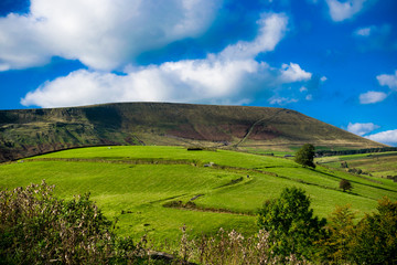 Z-shape uphill country road, Pendle Hill in distance, Summer,blue sky and white clouds, Forest Of Bowland, Lancashire, England, UK