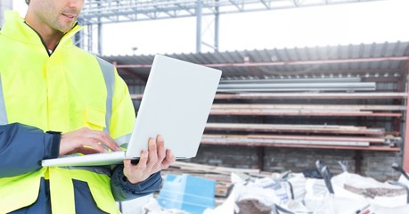 Male architecture using laptop at construction site