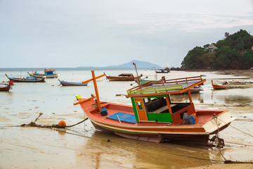 THAILAND, PHUKET, ASIA - FEBRUARY 1, 2017: Thai old fishing small boat at low tide in the shallows.