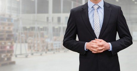 Mid section of businessman standing with hands clasped