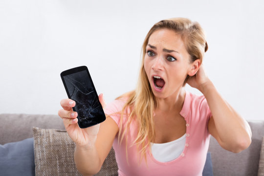 Shocked Woman Holding Damaged Phone