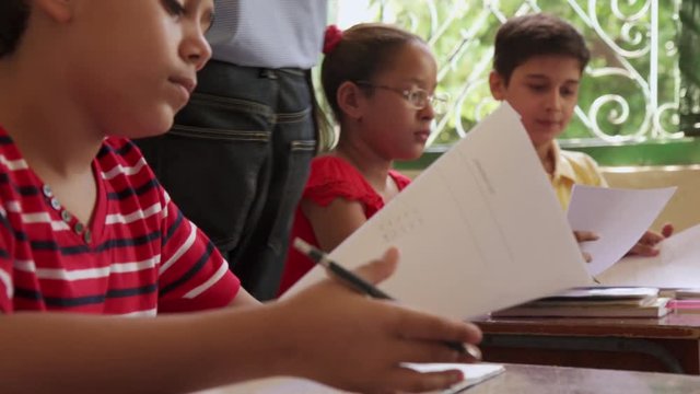 Young people and education. Group of hispanic students in class at school during lesson. Boys and girls with papers for admission test, examination