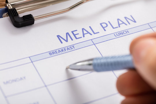 Person Hand Filling Meal Plan Form