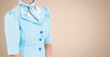 Air hostess standing against beige background - Powered by Adobe