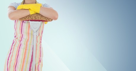 Female cleaner standing with mop against blue background