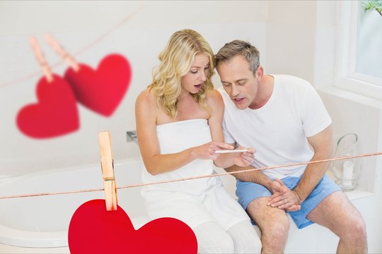 Composite image of couple using mobile phone at home in bathroom