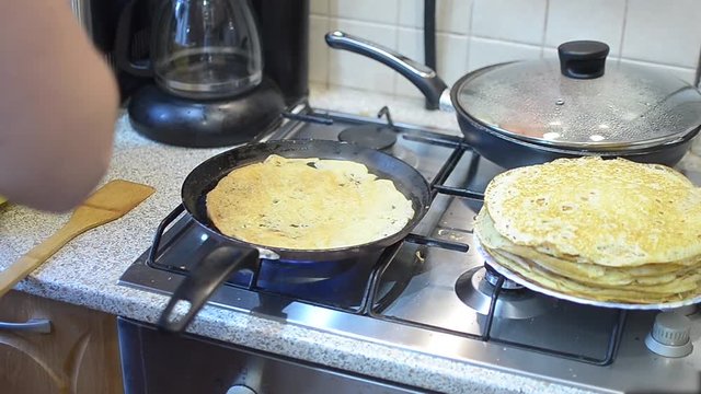 frying pancakes in a frying pan, cooking in the kitchen