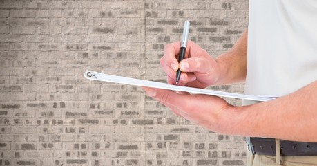 Mid section of man writing on a clipboard