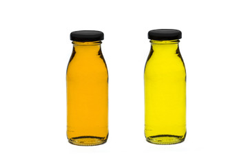Two bottles of plum and orange juice. Isolated on a white background. The bottle is reflected in the background.