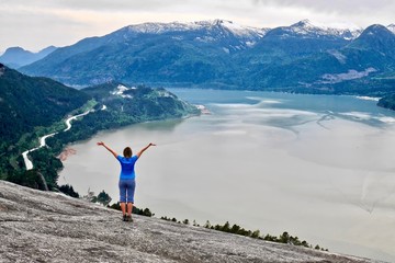 Hiking near Vancouver. Young woman on cliff over  the ocean. Stawamus Chief Peak. Squamish....