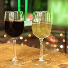 Red and white wine glasses on blurred lights background