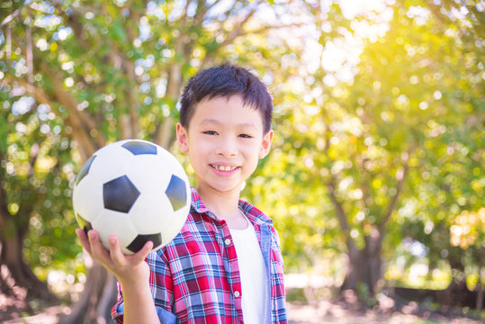 Young Asian boy with ball in park