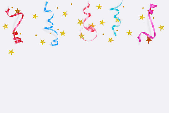 Colorful confetti stars, streamers on a light background.