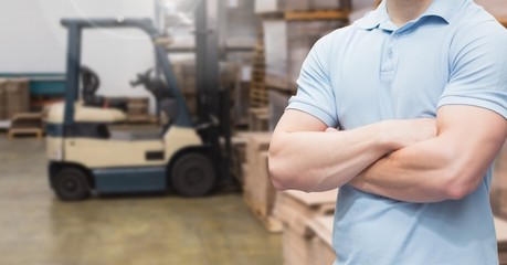 Manager standing with arms crossed in warehouse