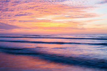 Naklejka na ściany i meble Landscape of the Sunrise with it reflecting in the ocean on Foll