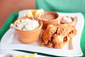 Traditional Brazilian lunch of fried chicken milanesa, rice, beans, and farofa on a plate at restaurant