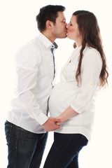 Glückliches Paar erwartet ein Baby und küssen sich