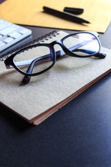 glasses and book on wooden table. film colors tone and soft-focus in the background. over light 