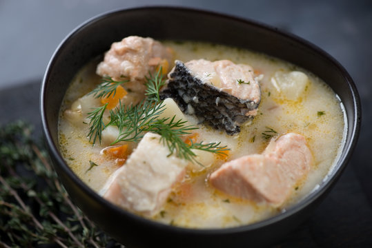 Close-up of ceramic bowl with salmon soup, selective focus