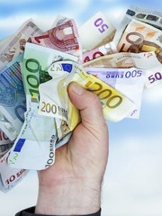 Hand holds bunch of crumpled cash