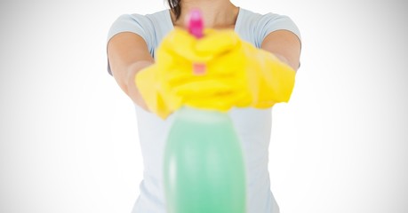 Female cleaner with yellow gloves holding a bottle