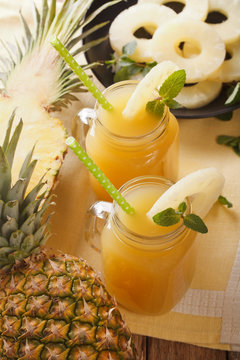 freshly squeezed pineapple juice in a glass jar closeup. vertical
